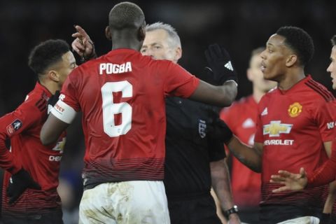 Manchester United's Paul Pogba argues with a referee Martin Atkinson during the English FA Cup Quarter Final soccer match between Wolverhampton Wanderers and Manchester United at the Molineux Stadium in Wolverhampton, England, Saturday, March 16, 2019. (AP Photo/Rui Vieira)