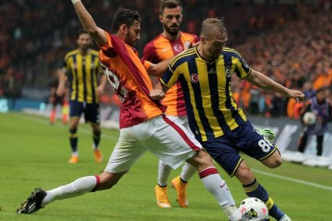 Galatasaray's Veysel Sari, left, and Caner Erkin of Fenerbahce fight for the ball during their Turkish League soccer derby match at the TT Arena stadium in Istanbul, Turkey, Saturday, Oct. 18, 2014.(AP Photo)