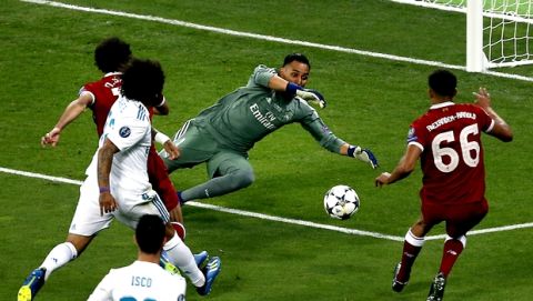 Real Madrid's goalkeeper Keylor Navas, center, saves a shot of Liverpool's Trent Alexander-Arnold, left, during the Champions League Final soccer match between Real Madrid and Liverpool at the Olimpiyskiy Stadium in Kiev, Ukraine, Saturday, May 26, 2018. (AP Photo/Darko Vojinovic)