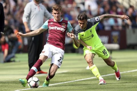 West Ham United's Sam Byram, left, and Liverpool's Philippe Coutinho battle for the ball during the English Premier League soccer match at London Stadium, Sunday May 14, 2017. (Adam Davy/PA via AP)