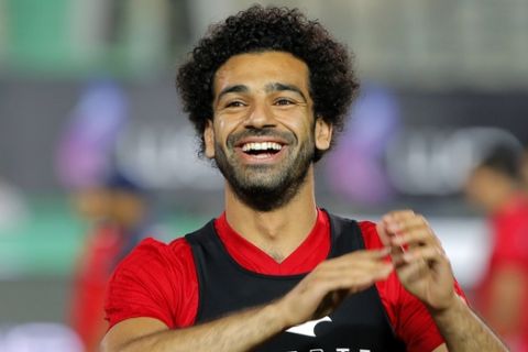 Egyptian national team soccer player and Liverpool's star striker Mohammed Salah smiles as he greets fans during the final training of the national team at Cairo Stadium in Cairo, Egypt, Saturday, June 9, 2018. About 2,000 fans gathered at Cairo's main stadium on Saturday to watch Egypt's last home practice before the Pharaohs fly to their World Cup base in Grozny, Chechnya. (AP Photo/Amr Nabil)