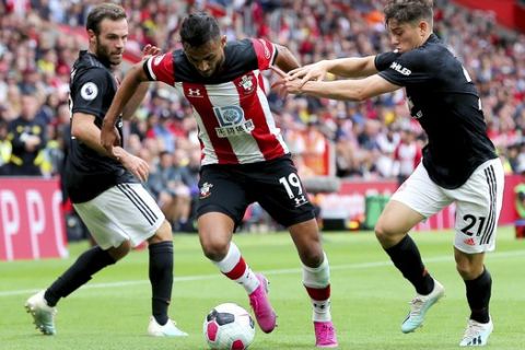 Southampton's Sofiane Boufal battles for the ball with Manchester United's Daniel James, right, and Juan Mata during the English Premier League soccer match at St Mary's, Southampton, England, Saturday Aug. 31, 2019. (Mark Kerton/PA via AP)
