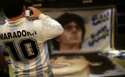 A member of the Church of Maradona takes a picture of a banner with the image of Diego Maradona in Buenos Aires, late Wednesday, Oct. 29, 2008. Diego Maradona's most devoted followers gathered on for a mock religious procession for the former soccer player's birthday and upcoming confirmation as Argentina coach. Maradona will turn 48 on Thursday. (AP Photo/Natacha Pisarenko)