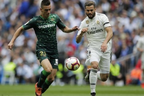 Betis player Lo Celso, left, duels for the ball against Real Madrid's Nacho Fernanzez during a Spanish La Liga soccer match at the Santiago Bernabeu stadium in Madrid, Spain, Sunday, May 19, 2019. (AP Photo/Bernat Armangue)