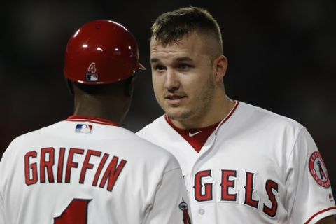 Los Angeles Angels center fielder Mike Trout, right, talks with first base coach Alfredo Griffin during the first inning of a baseball game against the Texas Rangers in Anaheim, Calif., Wednesday, Sept. 26, 2018. (AP Photo/Alex Gallardo)