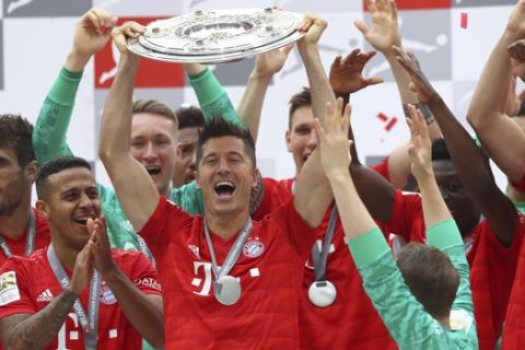 Bayern's Robert Lewandowski lifts the trophy to celebrate Bayern's 7th straight Bundesliga title after the German Soccer Bundesliga match between FC Bayern Munich and Eintracht Frankfurt in Munich, Germany, Saturday, May 18, 2019. (AP Photo/Matthias Schrader)