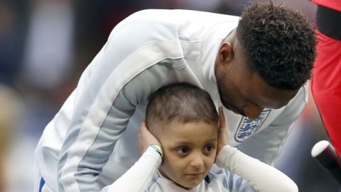 Bradley Lowery, front, and England's Jermain Defoe attend the national anthems prior to the World Cup Group F qualifying soccer match between England and Lithuania at the Wembley Stadium in London, Great Britain, Sunday, March 26, 2017. Bradley Lowery is battling a rare form of cancer and is set to lead England out onto the pitch at Wembley on March 26. (AP Photo/Kirsty Wigglesworth)
