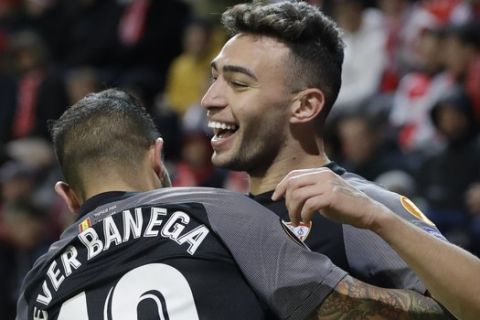 Sevilla's Munir is hugged by teammate Ever Banega after he scored his side's during their Europa League Round of 16 second leg soccer match between Slavia Praha and Sevilla at the Sinobo stadium in Prague, Czech Republic, Thursday, March 14, 2019. (AP Photo/Petr David Josek)