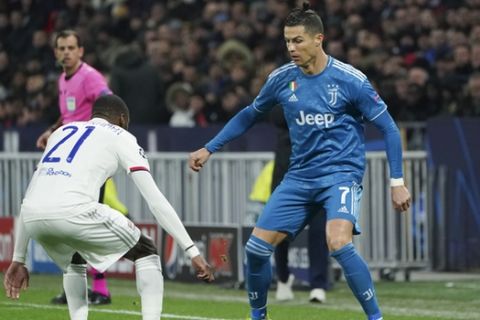Juventus' Cristiano Ronaldo, right, and Lyon's Karl Toko Ekambi vie for the ball during a round of sixteen, first leg, soccer match between Lyon and Juventus at the at the Lyon Olympic Stadium in Decines, outside Lyon, France, Wednesday, Feb. 26, 2020. (AP Photo/Laurent Cipriani)