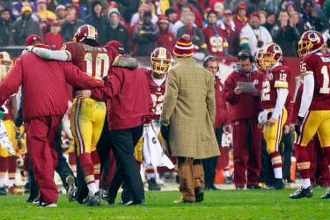 December 9, 2012; Landover, MD, USA; Washington Redskins quarterback Robert Griffin III (10) is helped off the field by team personnel after being injured against the Baltimore Ravens in the fourth quarter at FedEx Field. The Redskins won 31-28 in overtime. Mandatory Credit: Geoff Burke-USA TODAY Sports