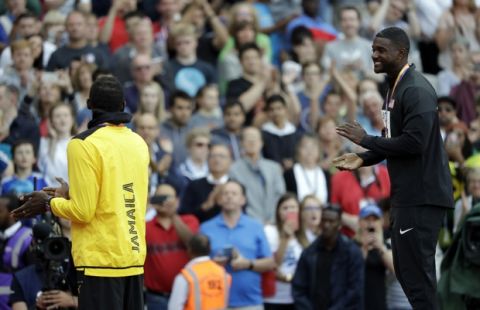 United States' gold medal winner Justin Gatlin, right, applauds Jamaica's bronze medal winner Usain Bolt during the ceremony for the men's 100-meter final at the World Athletics Championships in London Sunday, Aug. 6, 2017. (AP Photo/Matthias Schrader)