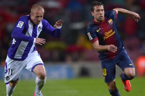 Barcelona's Jordi Alba, right, duels for the ball with Valladolid's Daniel Larsson during a Spanish La Liga soccer match at Camp Nou stadium in Barcelona, Sunday, May 19, 2013. (AP Photo/Manu Fernandez)