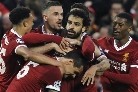 Liverpool's Mohamed Salah, center, celebrates with teammates after scoring his side's opening goal during the Champions League semifinal, first leg, soccer match between Liverpool and Roma at Anfield Stadium, Liverpool, England, Tuesday, April 24, 2018. (AP Photo/Rui Vieira)