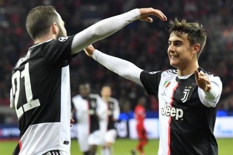 Juventus' Gonzalo Higuain, left, celebrates with Juventus' Paulo Dybala after scoring his side's second goal during the Champions League Group D soccer match between Bayer Leverkusen and Juventus at the BayArena in Leverkusen, Germany, Wednesday, Dec. 11, 2019. (AP Photo/Martin Meissner)