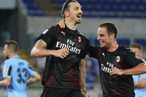 AC Milan's Zlatan Ibrahimovic, left, celebrates with Giacomo Bonaventura after scoring his side's 2nd goal on a penalty, during the Serie A soccer match between Lazio and AC Milan at the Rome Olympic stadium, Saturday, July 4, 2020. (Spada/LaPresse via AP)