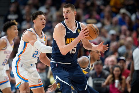Denver Nuggets center Nikola Jokic, right, fields a pass as Oklahoma City Thunder forward Isaiah Roby defends in the first half of an NBA basketball game Saturday, March 26, 2022, in Denver. (AP Photo/David Zalubowski)














