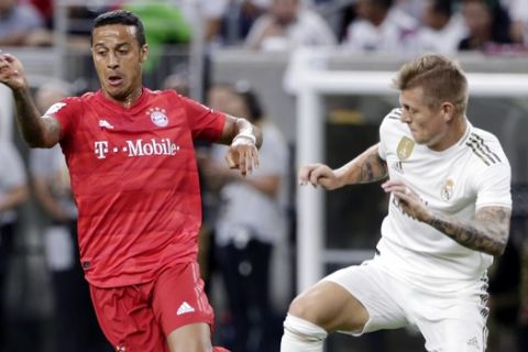 FC Bayern midfielder Thiago, left, moves the ball past Real Madrid midfielder Toni Kroos during the first half of an International Champions Cup soccer match Saturday, July 20, 2019, in Houston. (AP Photo/Michael Wyke)