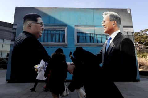 A visitor takes picture of an image of North Korean leader Kim Jong Un, left, and South Korean President Moon Jae-in displayed near the presidential Blue House in Seoul, South Korea, Thursday, Jan. 10, 2019. President Moon urged North Korea to take firmer disarmament measures and the U.S. to reward them, suggesting Thursday he'll push for sanction exemptions to restart dormant economic cooperation projects with the North.(AP Photo/Lee Jin-man)