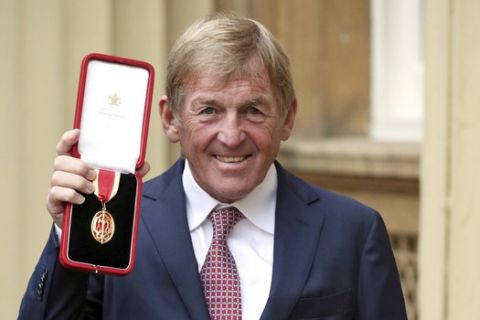 Liverpool soccer legend Kenny Dalglish poses with his medal after being knighted during an investiture ceremony at Buckingham Palace in London, Friday Nov. 16, 2018.  The honorary title of knighthood is bestowed by royal gift to recognise particular talents or charitable works. (Jonathan Brady/Pool via AP)