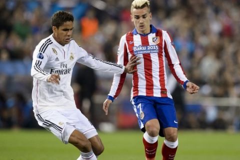 Real Madrid's French defender Raphael Varane (L) vies with Atletico Madrid's French midfielder Antoine Griezmann during the UEFA Champions League quarter final football match Atletico de Madrid vs Real Madrid CF at the Vicente Calderon stadium in Madrid on April 14, 2015.  AFP PHOTO / DANI POZO        (Photo credit should read DANI POZO/AFP/Getty Images)