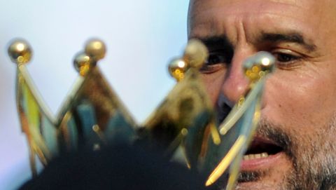 Manchester City manager Josep Guardiola looks at the English Premier League trophy after the soccer match between Manchester City and Huddersfield Town at Etihad stadium in Manchester, England, Sunday, May 6, 2018. (AP Photo/Rui Vieira)