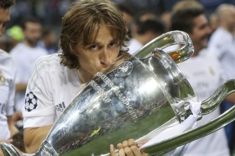 Real Madrid's Luka Modric kisses the trophy after the Champions League final soccer match between Real Madrid and Atletico Madrid at the San Siro stadium in Milan, Italy, Saturday, May 28, 2016. Real Madrid won 5-4 on penalties after the match ended 1-1 after extra time.  (AP Photo/Luca Bruno)