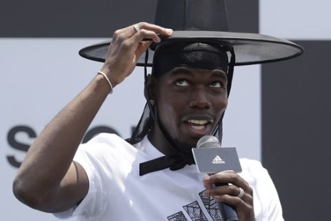 Manchester United's soccer player Paul Pogba, wearing the South Korean traditional hat, speaks during a media day in Seoul, South Korea, Thursday, June 13, 2019. Pogba is in Seoul as a part of his Asian tour. (AP Photo/Lee Jin-man)