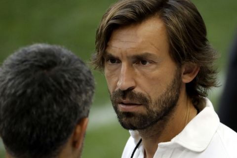 FILE - In this Friday, July 21, 2017 file photo, New York City FC's Andrea Pirlo, center, watches Juventus during a training session ahead of an International Champions Cup soccer match against Barcelona, in Harrison, N.J.  Andrea Pirlo is one step closer on the road to football management. The 39-year-old Pirlo was one of a number of ex footballers who obtained their UEFA A coaching badges on Thursday, Sept. 27, 2018 after completing a course of several months at the Italian football federations training complex in Coverciano. (AP Photo/Julio Cortez, File)