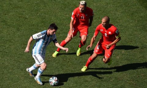 SAO PAULO, BRAZIL - JULY 01: Lionel Messi of Argentina controls the ball against Valon Behrami (C) and Gokhan Inler of Switzerland during the 2014 FIFA World Cup Brazil Round of 16 match between Argentina and Switzerland at Arena de Sao Paulo on July 1, 2014 in Sao Paulo, Brazil.  (Photo by Matthias Hangst/Getty Images)