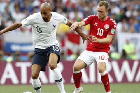France's Steven Nzonzi, left, challenges for the ball with Denmark's Christian Eriksen during the group C match between Denmark and France at the 2018 soccer World Cup at the Luzhniki Stadium in Moscow, Russia, Tuesday, June 26, 2018. (AP Photo/Antonio Calanni)