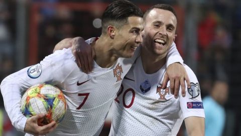 Portugal's Cristiano Ronaldo, left, celebrates with his teammate Diogo Jota after he scored his side's second goal during the Euro 2020 group B qualifying soccer match between Luxembourg and Portugal at the Josy Barthel stadium in Luxembourg, Sunday, Nov. 17, 2019. (AP Photo/Francisco Seco)