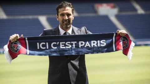 PSG's new signing goalkeeper Gianluigi Buffon displays a scarf reading "here is Paris" during his official presentation at the Parc des Princes stadium in Paris, France, Monday, July 9, 2018. Free agent Gianluigi Buffon signed for Paris Saint-Germain last Friday. The veteran goalkeeper penned a one-year deal at the French champion with the option for an additional season. (AP Photo/Jean-Francois Badias)