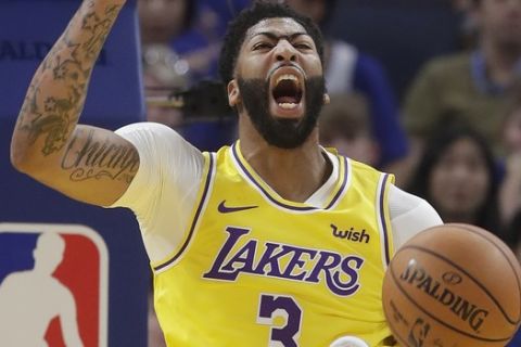 Los Angeles Lakers forward Anthony Davis (3) yells after dunking against the Golden State Warriors during the first half of a preseason NBA basketball game in San Francisco, Saturday, Oct. 5, 2019. (AP Photo/Jeff Chiu)