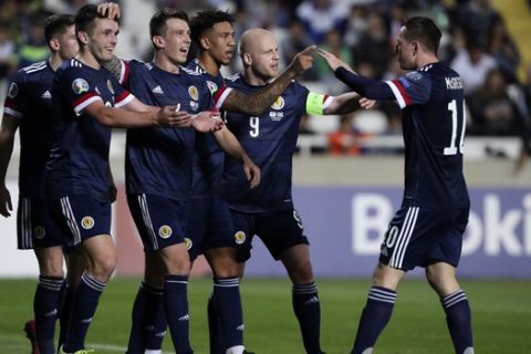 Scotland's John MgGinn, left, celebrates with his teammates after scoring his side's second goal during the Euro 2020 group I qualifying soccer match between Cyprus and Scotland at GSP stadium in Nicosia, Saturday, Nov. 16, 2019. (AP Photo/Petros Karadjias)