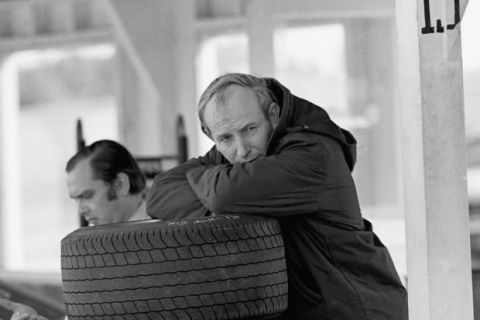 John Surtees of England, driver head resting on arms, leaning against pile of tires in 1969. (AP Photo)