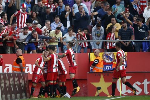 Girona's Cristhian Stuani, is mobbed by teammates as he celebrates after scoring his sides first goal of the game during the La Liga soccer match between Girona and Real Madrid at the Montilivi stadium in Girona, Spain, Sunday, Oct. 29, 2017. (AP Photo/Manu Fernandez)