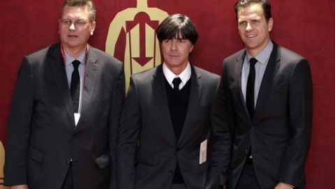 Germany national soccer coach Joachim Loew, center, the head of the German football federation Reinhard Grindel, left, and team manager Oliver Bierhoff pose for the photographers before the 2018 soccer World Cup draw in the Kremlin in Moscow, Friday, Dec. 1, 2017. (AP Photo/Dmitri Lovetsky)