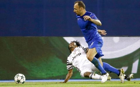 Juventus's Juan Cuadrado, bottom, is fouled by Zagreb's Gordon Schildenfeld during the Champions League Group H soccer match between Dinamo Zagreb and Juventus, at Maksimir stadium in Zagreb, Croatia, Tuesday, Sept. 27, 2016. (AP Photo/Darko Bandic) 