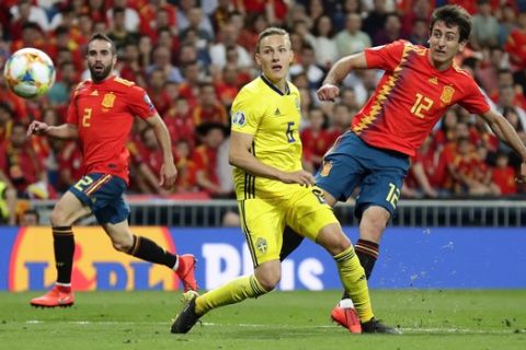 Spain's Mikel Oyarzabal, right, shoots to score his side's third goal during the Euro 2020 Group F qualifying soccer match between Spain and Sweden at the Santiago Bernabeu stadium in Madrid, Monday June 10, 2019. (AP Photo/Manu Fernandez)