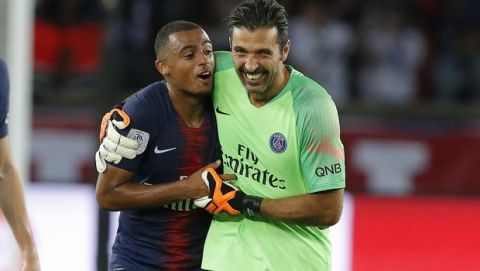PSG's goalkeeper Gianluigi Buffon, right, and PSG's Antoine Bernede celebrate victory in their League One soccer match between Paris Saint-Germain and Caen at Parc des Princes stadium in Paris, Sunday, Aug. 12, 2018. (AP Photo/Michel Euler)