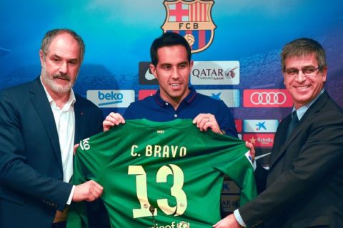BARCELONA, SPAIN - JULY 07:  Claudio Bravo (C) poses with the FC Barcelona Sport director Andoni Zubizarreta and FC Barcelona Vice-President Jordi Mestre as a new player for FC Barcelona at the Camp Nou Stadium on July 7, 2014 in Barcelona, Spain.  (Photo by David Ramos/Getty Images)