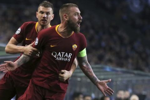 Roma midfielder Daniele De Rossi celebrates with forward Edin Dzeko, background, after scoring his side's first goal during the Champions League round of 16, 2nd leg, soccer match between FC Porto and AS Roma at the Dragao stadium in Porto, Portugal, Wednesday, March 6, 2019. (AP Photo/Luis Vieira)