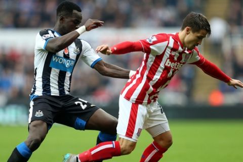 Newcastle United's Cheick Tiote, left, vies for the ball with  Stoke City's Bojan Krkic, right, during their English Premier League soccer match between Newcastle United and Stoke City at St James' Park, Newcastle, England, Saturday, Oct. 31, 2015. (AP Photo/Scott Heppell)