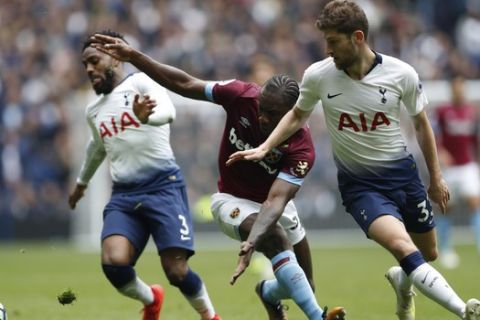 West Ham's Michail Antonio, center, is flanked by Tottenham Hotspur's Ben Davies, right, and Tottenham Hotspur's Danny Rose during the English Premier League soccer match between Tottenham Hotspur and West Ham United at White Hart Lane in London, Saturday, April, 27, 2019. (AP Photo/Alastair Grant)