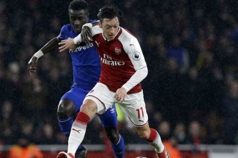 Arsenal's Mesut Ozil, right, vies for the ball with Everton's Idrissa Gueye during the English Premier League soccer match between Arsenal and Everton at the Emirates stadium in London, Saturday, Feb. 3, 2018. (AP Photo/Alastair Grant)