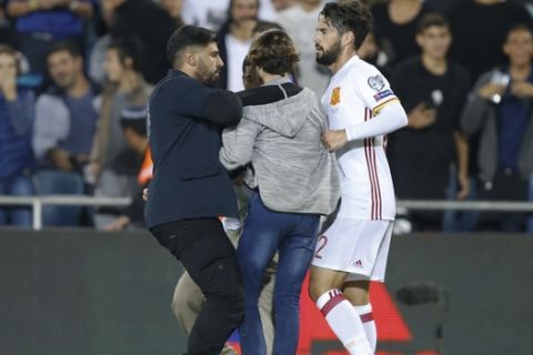 Spain's, Isco and a security guard evict an Israeli fan who entered the pitch during the World Cup Group G match in Jerusalem, Monday, Oct.9, 2017. (AP Photo/Ariel Schalit)