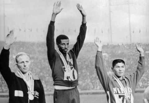 The three winners of the marathon event at the Tokyo Olympics stand side by side on the rostrum, 23rd October 1964. From left to right, they are Basil Heatley of Great British (silver), Abebe Bikila of Ethiopia (gold) and Kokichi Tsuburaya of Japan (bronze). Bikila also set a world record of 2 hours, 12.11 minutes.  (Photo by Keystone/Hulton Archive/Getty Images)