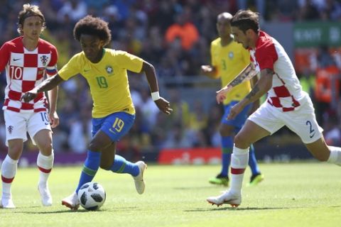 Brazil's Willian, centre, battles for the ball with Croatia's Luka Modric, left, and Croatia's Sime Vrsaljko during the friendly soccer match between Brazil and Croatia at Anfield Stadium in Liverpool, England, Sunday, June 3, 2018. (AP Photo/Dave Thompson)