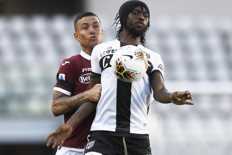 Torino's Armando Izzo, left, challenges Parma's Gervinho, during the Serie A soccer match between Torino and Parma, at the Olympic Stadium in Turin, Italy, Saturday, June 20, 2020. Serie A restarts Saturday following the easing of restrictions due to the COVID-19 pandemic, with matches being played without spectators because of the coronavirus lockdown. (Fabio Ferrari/LaPresse via AP)
