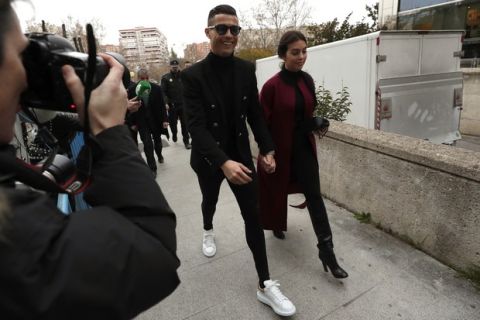 Cristiano Ronaldo arrives at the court in Madrid on Tuesday, Jan. 22, 2019. Cristiano Ronaldo is expected to plead guilty to tax fraud. The Juventus forward arrived in a black van, walked up some stairs leading to the court house and stopped to sign an autograph. The charges stem from his days at Real Madrid. (AP Photo/Manu Fernandez)
